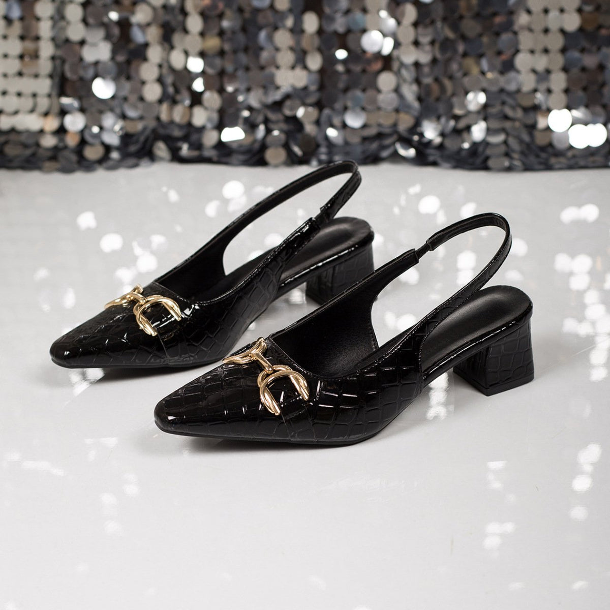 Sophie Croc Slingbacks in Black — angled pair showing the gold horsebit buckle and pointed toe