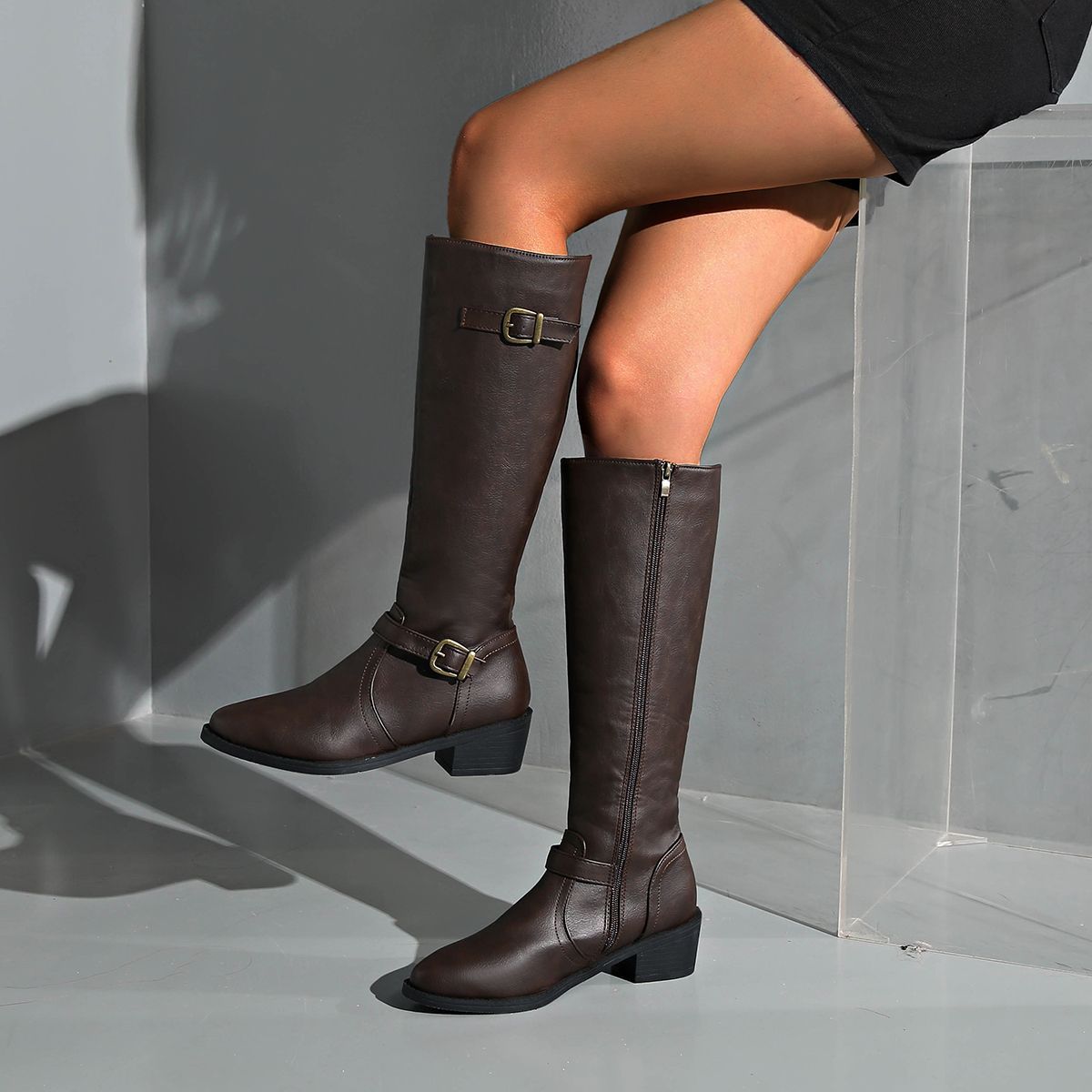 Delia Knee-High Boots in Dark Brown — front view of the leather upper and buckle straps
