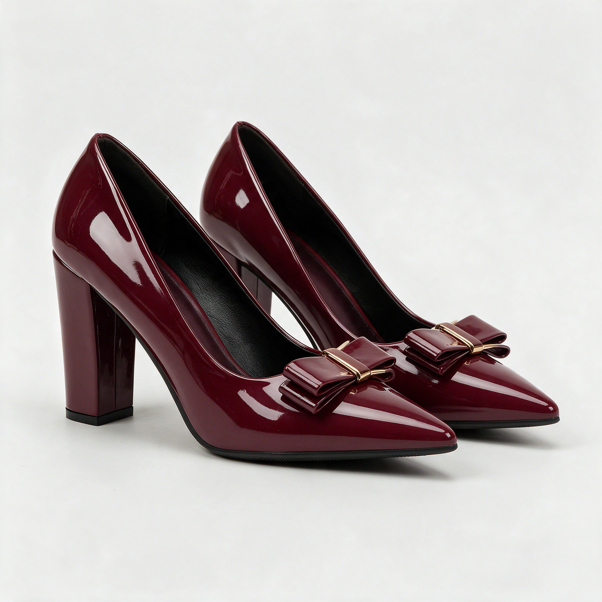 Giulia Bow Pumps in Burgundy — patent pointed-toe pump with a gold-barred bow