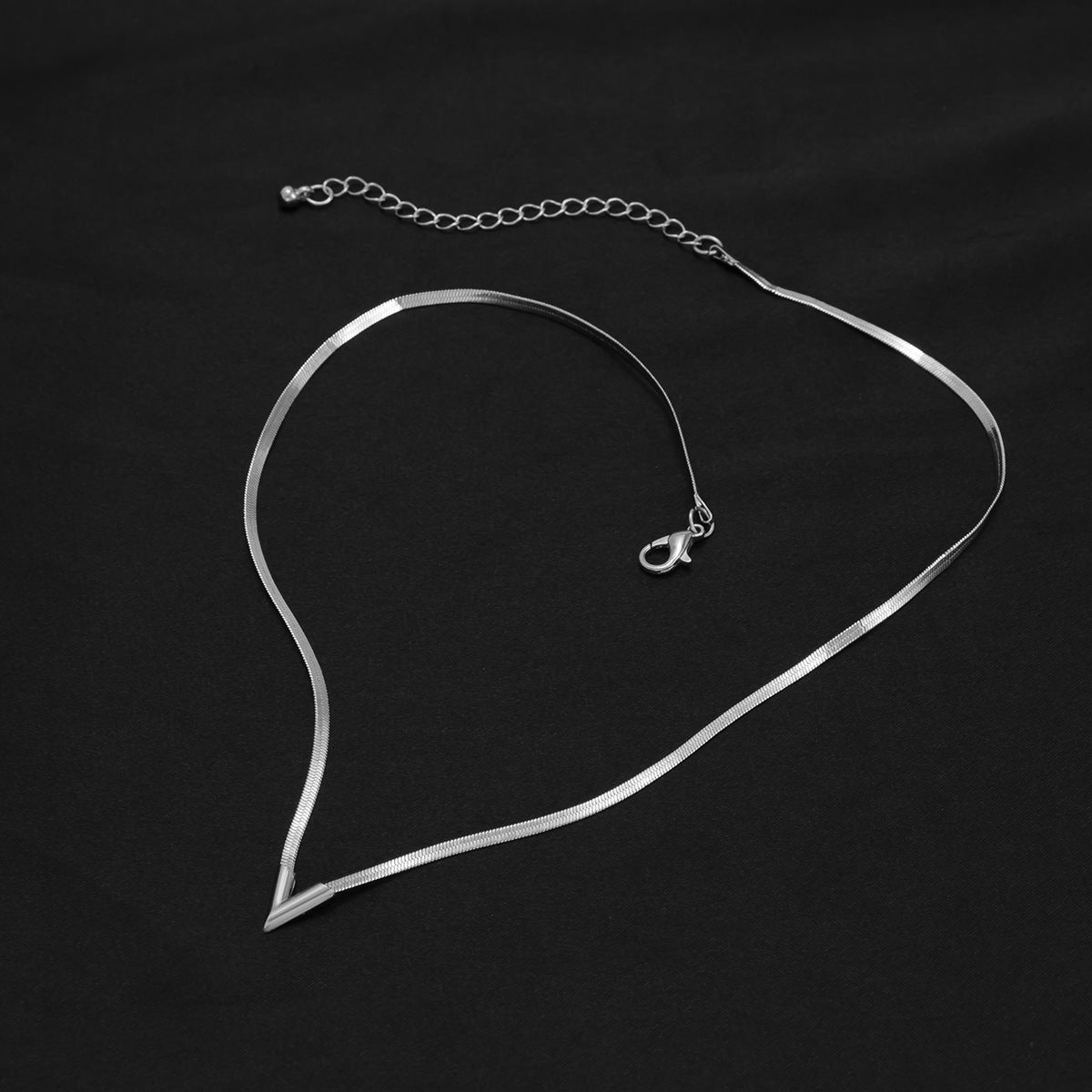 Felix Necklace — polished snake-chain V-drop necklace detail view