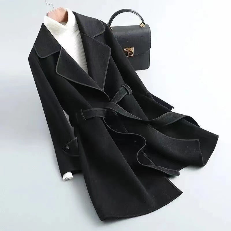 Delphine Wool Coat in Black — women's belted wool coat with contrast piping, tie belt, and notched lapel