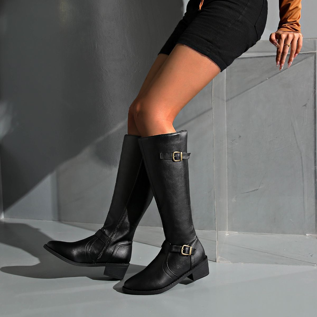 Delia Knee-High Boots in Black — worn with the buckle straps at the ankle and shaft