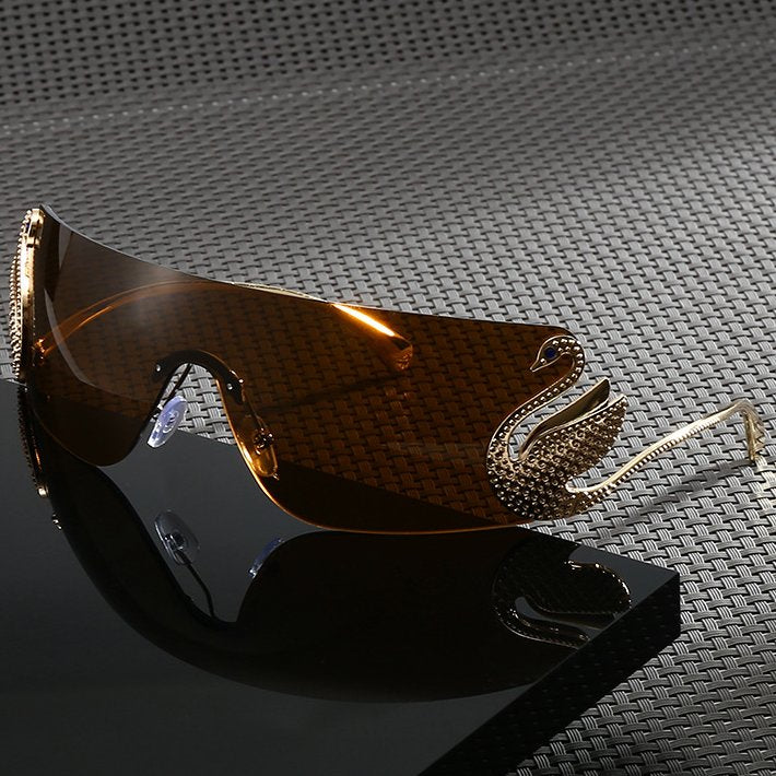 Bianca Sunglasses in Brown — gold-tone wraparound with sculpted swan accent