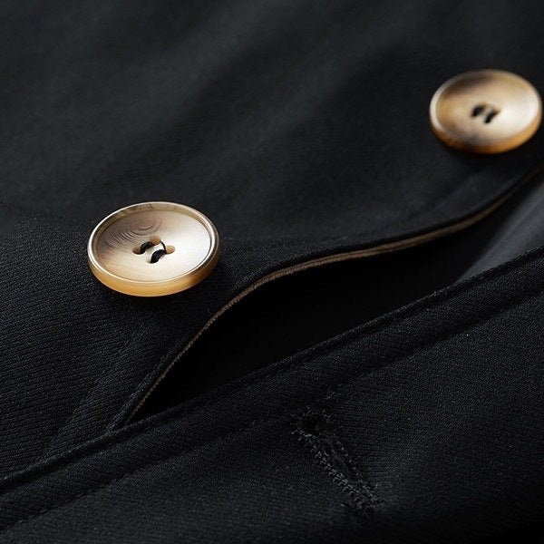 Sutton Trench Coat in Black — close-up of the horn-tone buttons and clean twill stitching