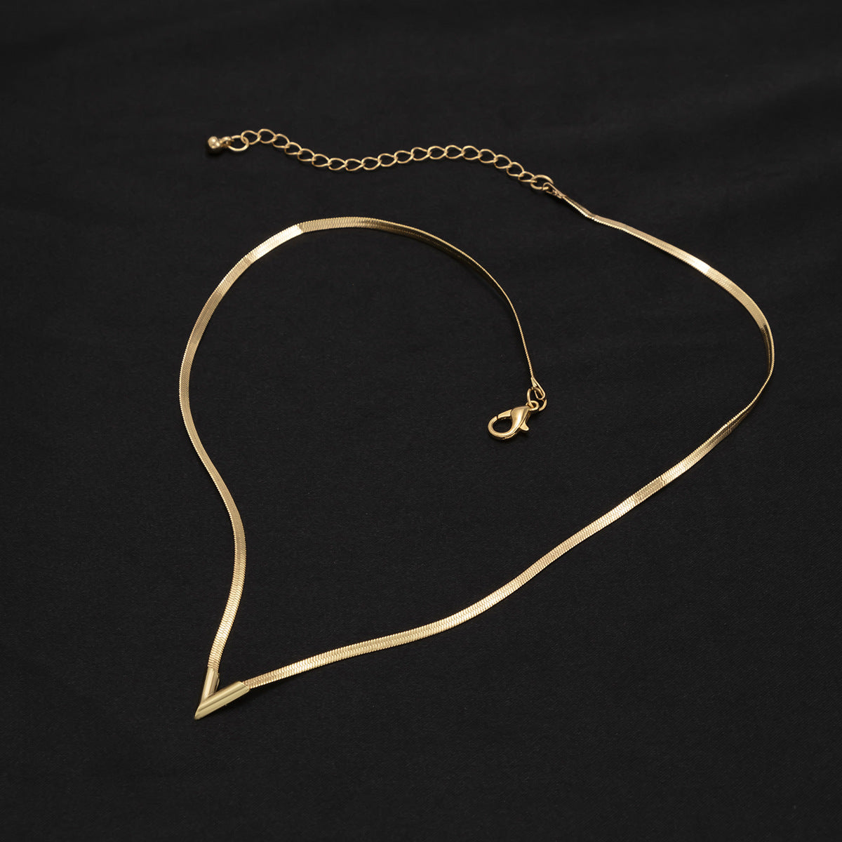 Felix Necklace — polished snake-chain V-drop necklace detail view