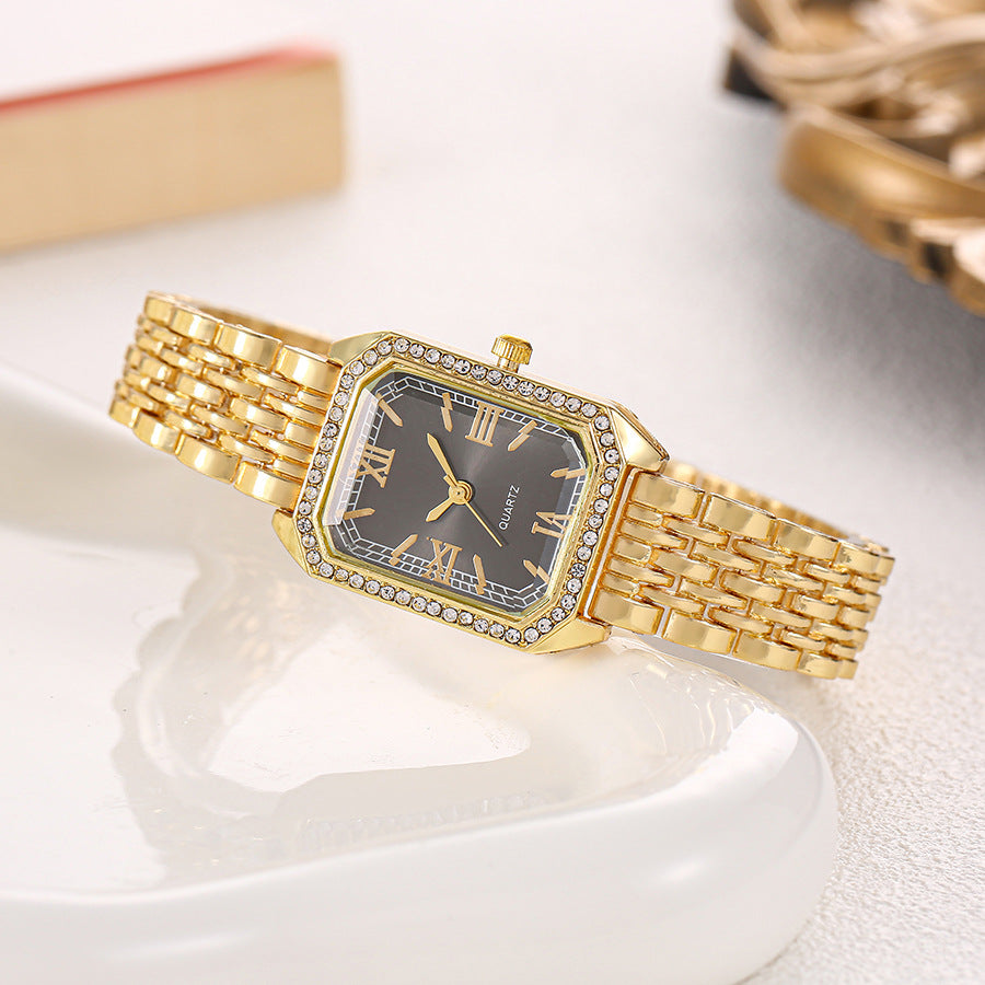 Seraphine Crystal Watch in Black — gold-tone bracelet watch with crystal-lined bezel and Roman numerals
